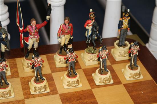 A Waterloo chess set by Charles Stadden, No. 27/250, in military style brass-bound mahogany games table on folding stand